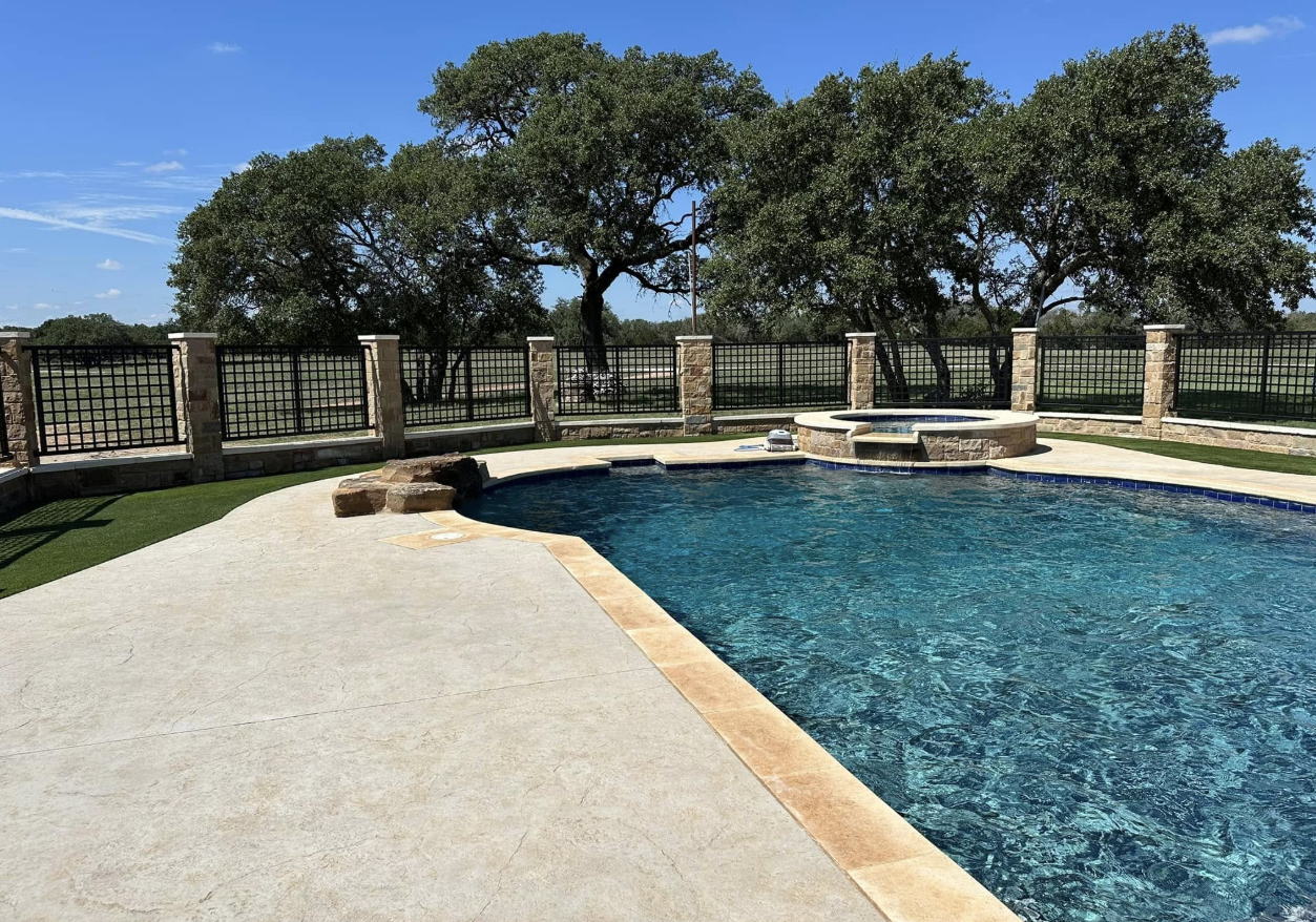 Pool with custom iron fence panels and stone columns